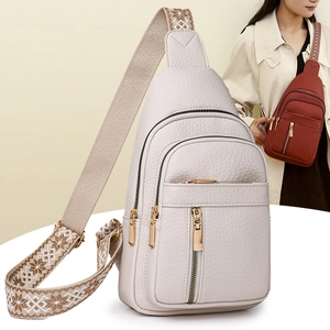 Close-up of white lychee grain leather crossbody bag with ethnic snowflake jacquard strap