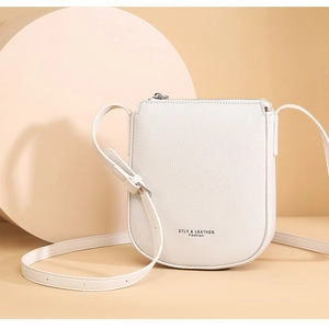 Minimalist beige lychee grain leather crossbody bag with adjustable strap and metal zipper