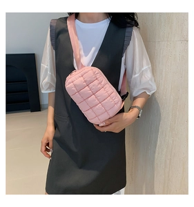 Detailed close-up of pink quilted puffer crossbody bag worn with a casual outfit