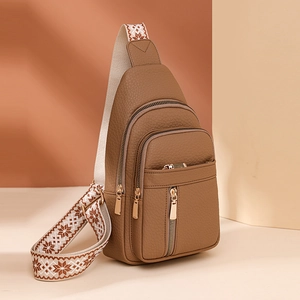 Brown lychee leather crossbody bag with wide patterned strap and golden hardware