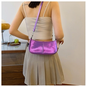 Sac à bandoulière en similicuir violet métallisé porté par un mannequin en intérieur