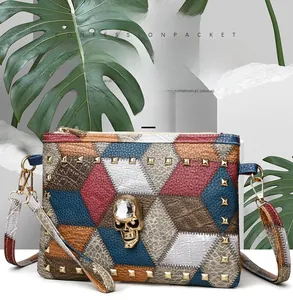 Detail of color-block patchwork handbag with gold rivets and rhinestone skull decor