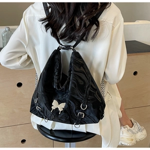 Detail of marble textured PU leather backpack with butterfly logo on model's back