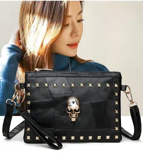 Detail of black punk handbag with golden square rivets and crystal skull decoration