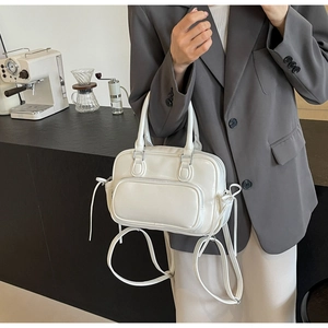 Close-up of a white PU leather handbag with a front pocket and adjustable shoulder strap
