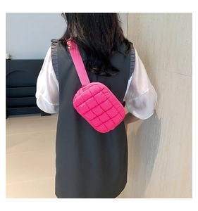 Detail view of pink quilted crossbody bag with adjustable wide fabric strap