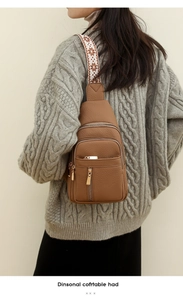 Detail of brown litchi pattern sling bag with wide ethnic strap and gold zippers