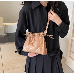 Detailed view of brown quilted PU leather bucket bag with elegant drawstring closure