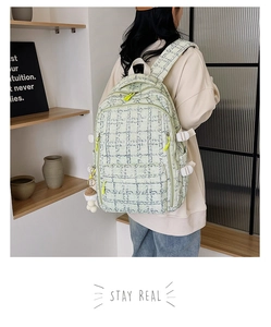 Détail d'un sac à dos en velours vert clair avec texture tissée et zips jaune néon