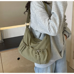 Detail der olivgrünen Segeltuchtasche mit doppelten Kordelzugtaschen und Metallschnallen