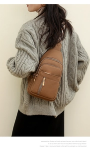 Detail view of brown pebbled leather crossbody bag with ethnic style woven shoulder strap