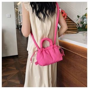 Detailed back view of a pink drawstring cloud bag worn as a casual crossbody bag