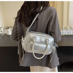 Detail of silver metallic crossbody bag featuring crushed texture and double zippers
