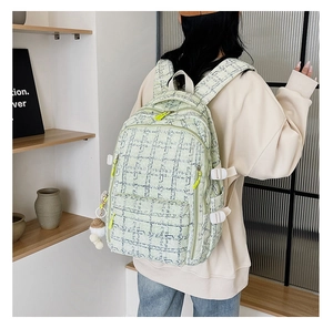 Détail du sac à dos en velours côtelé vert clair avec texture tissée et pompon