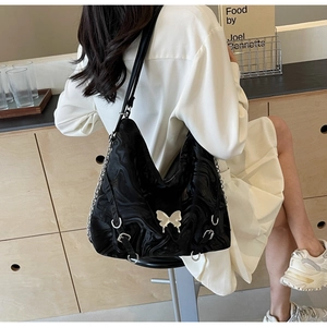 Detail of black butterfly buckle tote bag with marble texture and silver chain strap