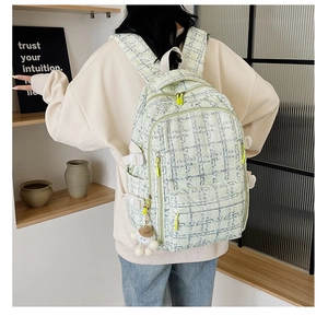 Détail du sac à dos en velours côtelé à carreaux verts avec fermeture éclair jaune fluo