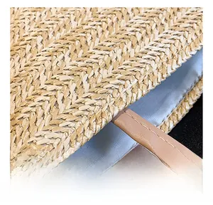 Detail of woven straw bag showing blue lining and brown leather handle stitching