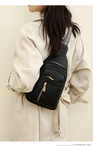 Close-up of black pebbled leather chest bag featuring ethnic pattern shoulder strap