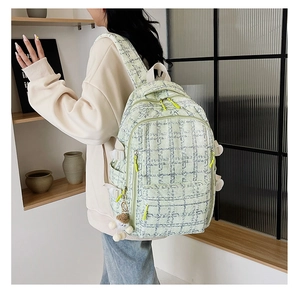 Détail du sac à dos en velours côtelé à carreaux avec zips néon et charm en peluche