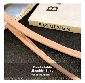 Detail of soft pink leather shoulder strap with fine white stitching on woven tote bag