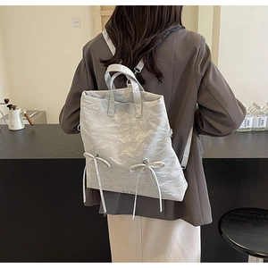 Detail of silver pleated PU backpack with twin bows and adjustable shoulder straps