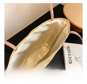 Top view of the spacious inner compartment of this woven tote bag with a white fabric lining