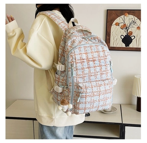 Vue détaillée du sac à dos en velours côtelé avec motifs à carreaux et porte-clés ourson