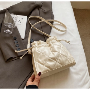 Chic beige quilted PU leather bucket bag with drawstring closure and slim shoulder strap