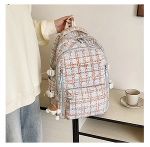 Détail d'un sac à dos en tweed bleu avec un charmant champignon et un pompon doux