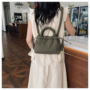 Army green quilted backpack with soft padded texture and drawstring closure detail
