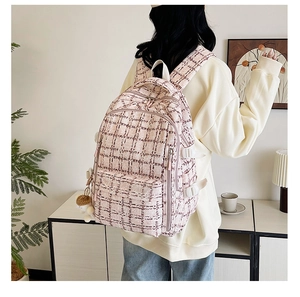 Détail d'un sac à dos en velours côtelé rose et blanc avec plusieurs poches zippées