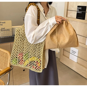 Close-up of woven paper straw handbag with wooden bead handles and canvas inner pouch