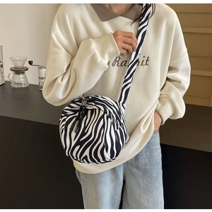 Vue détaillée du sac bandoulière en tissu zébré avec large sangle et fermeture