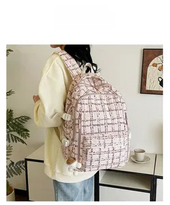 Détail d'un sac à dos en velours côtelé à carreaux roses avec pendentif champignon