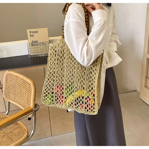Detail of woven straw tote bag with brown wooden bead handles in a vintage lifestyle setting