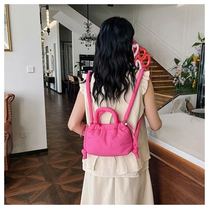 Detailed back view of a vibrant magenta quilted drawstring backpack with top handles