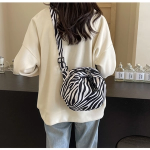 Détail du sac bandoulière en tissu à motif zèbre avec une large sangle réglable