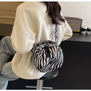 Détail du sac bandoulière à motif zébré avec des doubles fermetures éclair noires