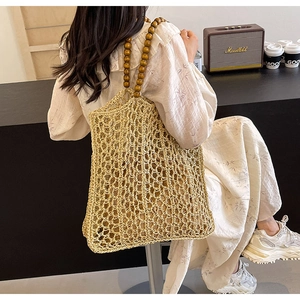 Detail of bohemian woven tote bag showing natural fibers and dark wood bead handles