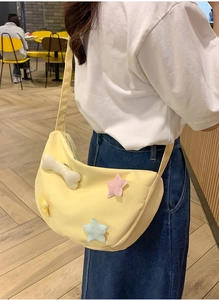 Vue détaillée du sac bandoulière en nylon jaune avec d'adorables étoiles en peluche