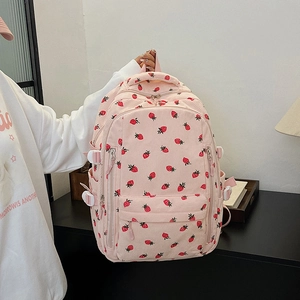 Détail du sac à dos en velours côtelé rose avec motifs fraises et poche frontale