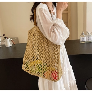 Detail of woven mesh tote bag with wooden beads strap showing capacity and texture