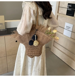 Vista dettagliata della borsa tote in paglia intrecciata con lunghe nappe e stile floreale