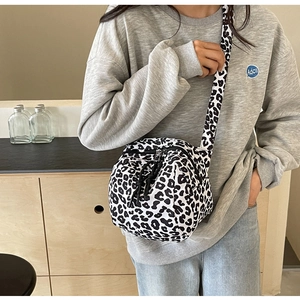 Détail d'un sac bandoulière léopard rond avec doubles fermetures éclair et cordons