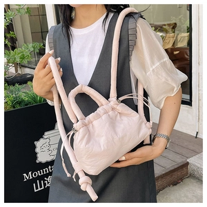 Detail view of pink puffy cloud backpack with drawstring and knotted rope straps