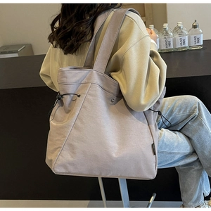 Detail view of large canvas tote bag in grey purple with side drawstring adjustment