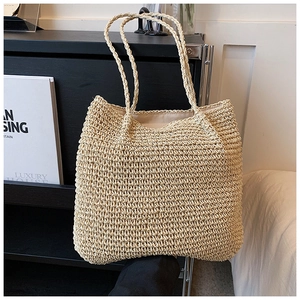 Detailed view of handwoven straw tote bag with fine crochet texture and long handles