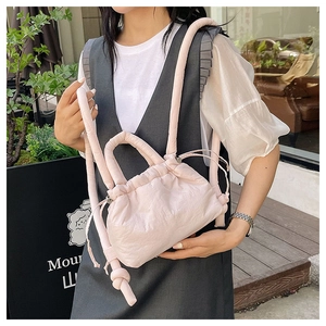 Close-up of quilted bubble fabric texture and drawstring closure on light pink bag