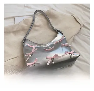 Detail of silver metallic PU hobo bag featuring pink ribbon bows and white pearl charms