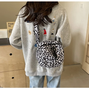 Gros plan du sac bandoulière léopard avec forme en croissant et large bandoulière